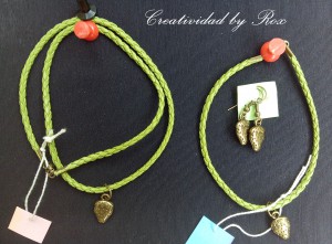 Conjunto de gargantilla, pulsera y pendientes con fresitas de metal color bronce. Cordón cuero verde. 